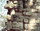 26 figures carved in stone on a stone block wall in the maya ruins of copan